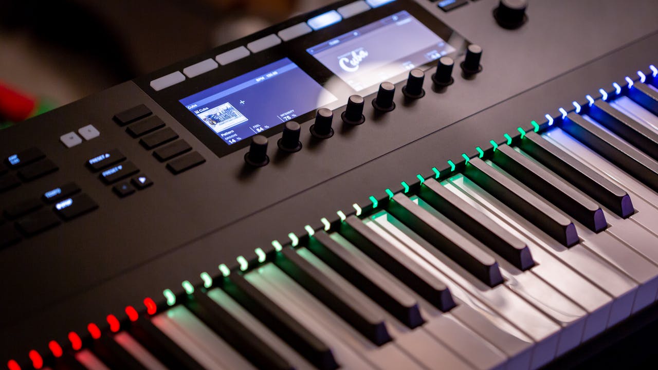 gallery-1 Close-up of an electronic keyboard with colorful illuminated keys in a studio setting.