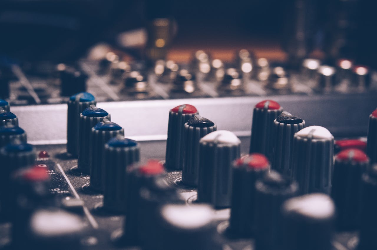 hero-img-02 Close-up of audio mixer knobs in a dimly lit studio. Perfect for music and technology themes.